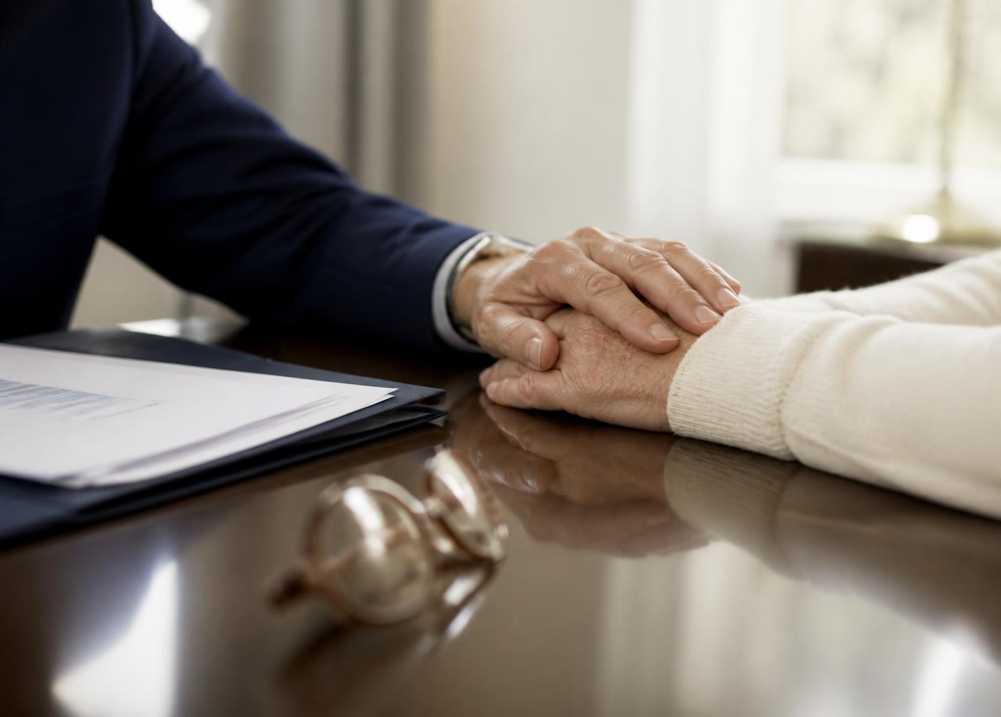 Settlement documents and reading glasses on a table during a private review